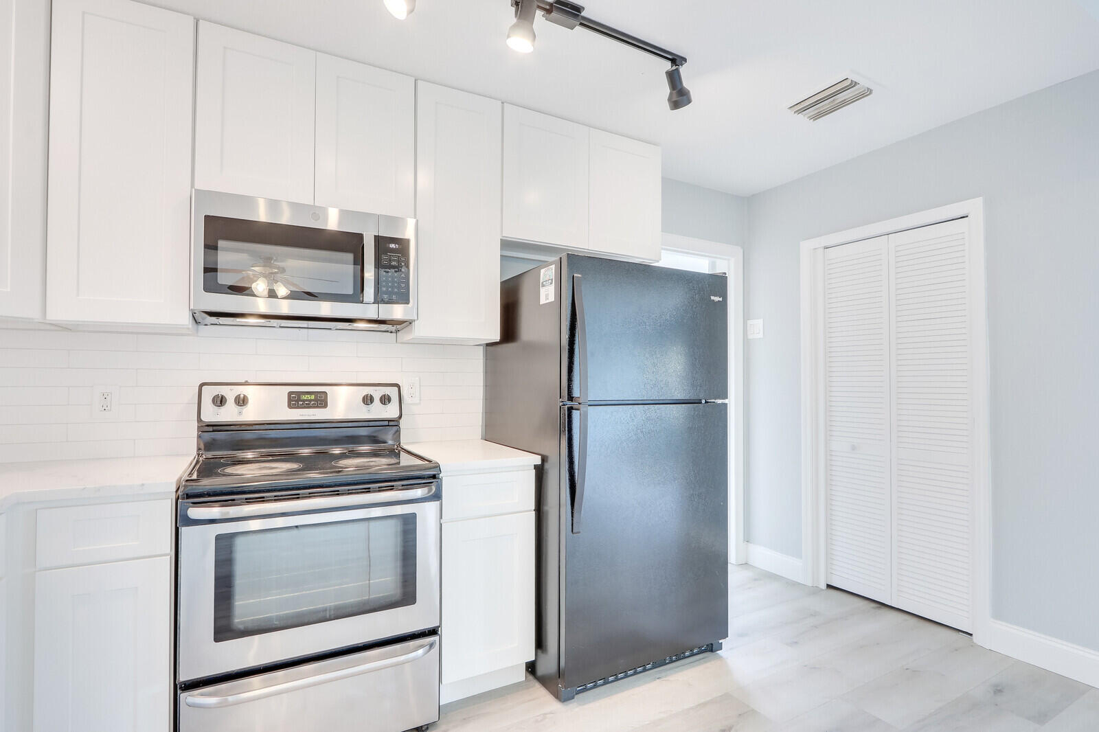 3852 Gull Road Palm Beach Gardens, FL 33410 - Photo 9 of 30 a kitchen with stainless steel appliances a refrigerator stove and microwave