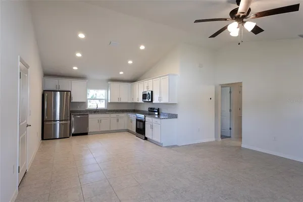 a kitchen with stainless steel appliances kitchen island sink refrigerator and cabinets