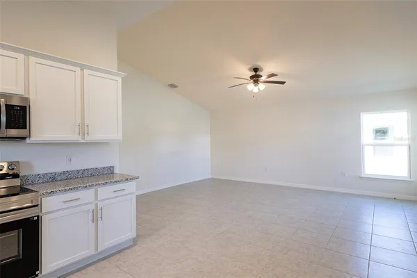a kitchen with cabinets stainless steel appliances and a window