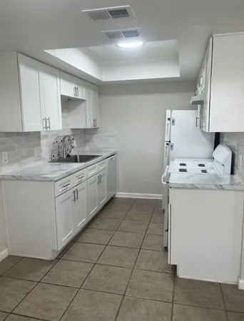 a kitchen with a sink a stove and cabinets