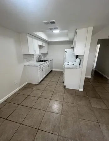 a kitchen with a sink a stove and cabinets