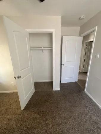 an empty room with closet and mirror