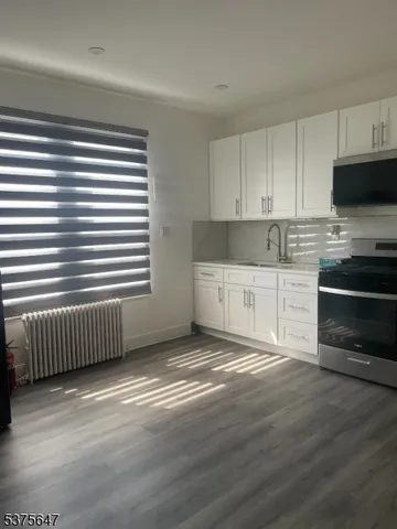 a view of kitchen with cabinets and wooden floor