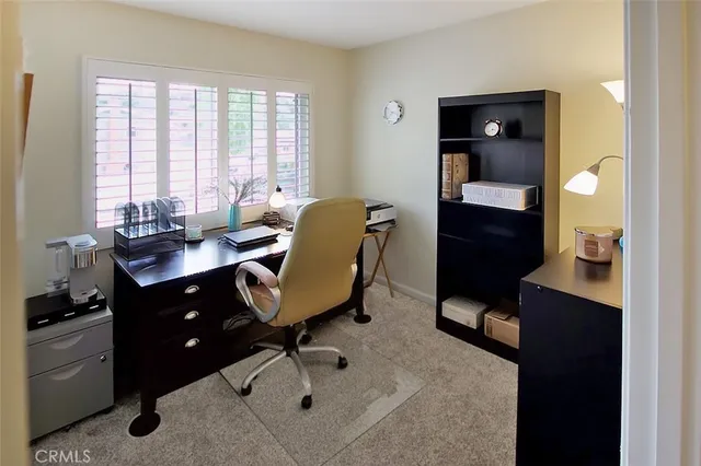 a view of a workspace with furniture and a window