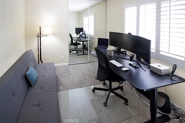 a view of a workspace with furniture and a window