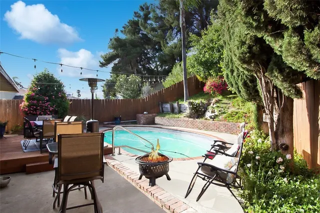 a backyard of a house with fire pit and outdoor seating