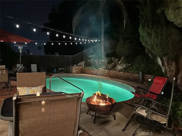 a view of a swimming pool with lawn chairs under an umbrella