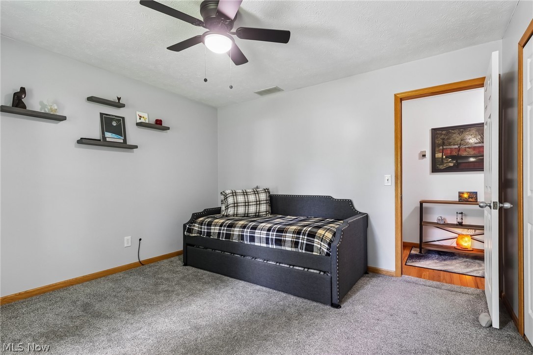 3213 Bates Road Madison, OH 44057 - Photo 27 of 45 Interior room with light gray walls, gray carpeting, a ceiling fan with integrated lighting, and wood-trim door frames