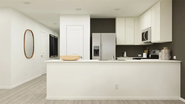 a kitchen with stainless steel appliances granite countertop a sink a stove and a refrigerator with wooden floor