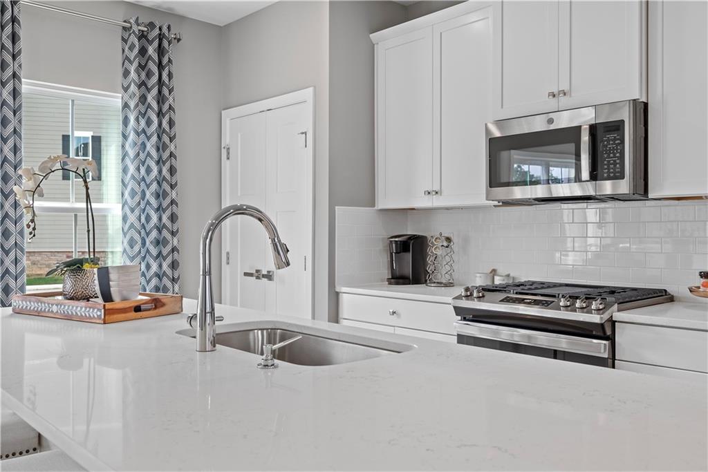 8100 Walnut Way Gibsonia, PA 15044 - Photo 12 of 40 a kitchen with granite countertop a stove a sink and a microwave