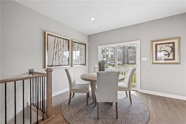 a view of a dining room with furniture a couch and wooden floor
