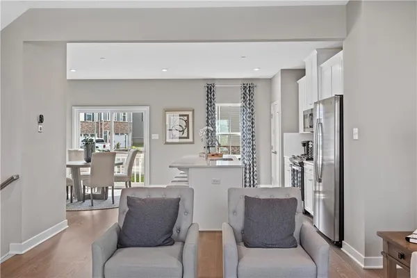 a living room with furniture a large window and a wooden floor