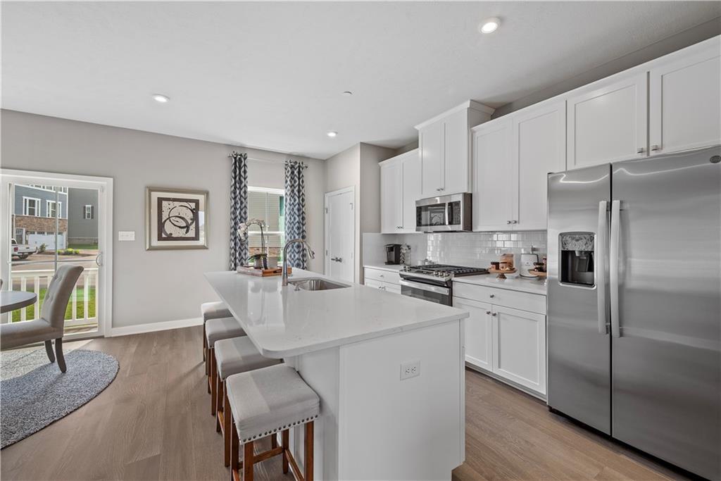 8100 Walnut Way Gibsonia, PA 15044 - Photo 8 of 40 a kitchen with stainless steel appliances a refrigerator a stove a sink a dining table and chairs