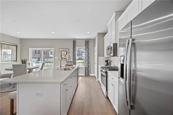 a kitchen with stainless steel appliances granite countertop a refrigerator a stove and a sink