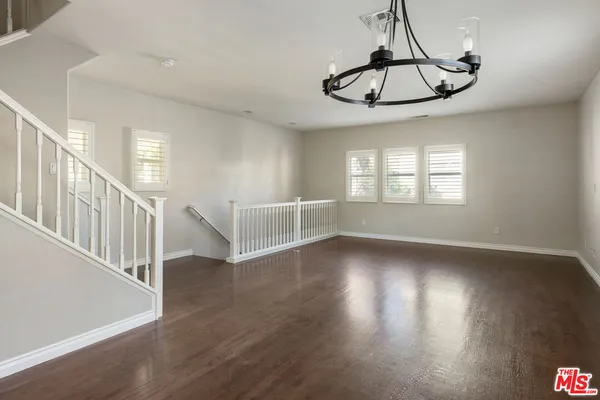 a view of a room with wooden floor fan and windows