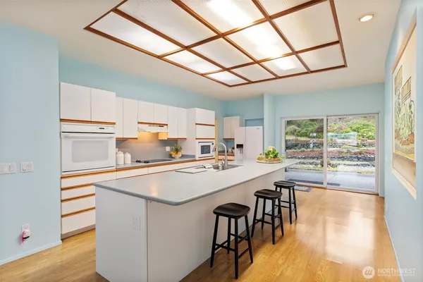a kitchen with kitchen island a stove a table and chairs in it