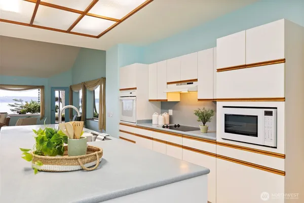 a dining table with a fireplace and kitchen view
