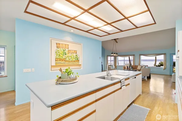 a dining hall with stainless steel appliances granite countertop a sink a counter space and a window