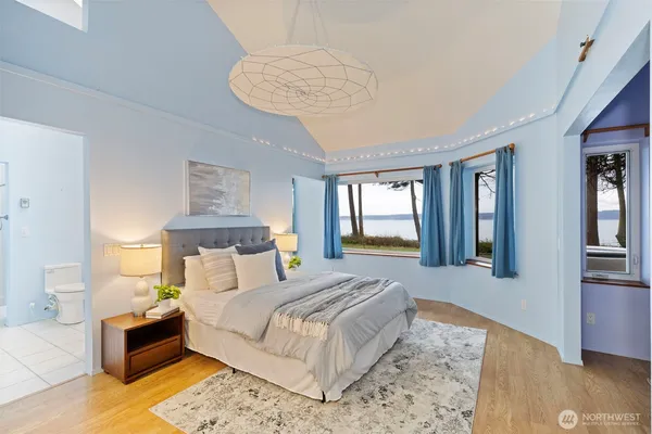 a bedroom with a large bed and a chandelier