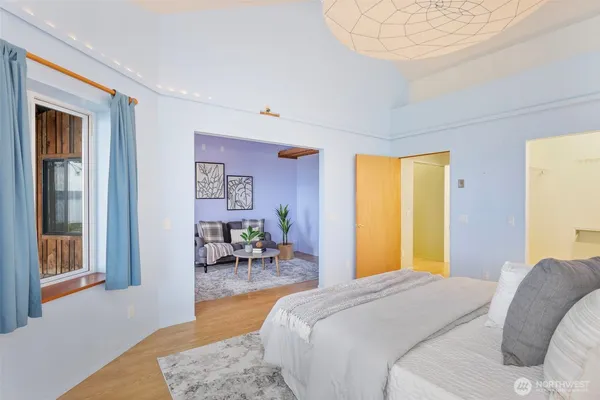 a bedroom with a bed and wooden floor