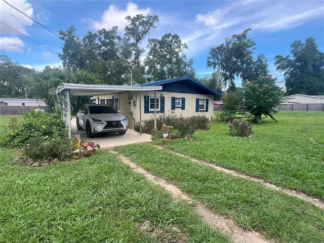 a car parked in front of a house with a big yard