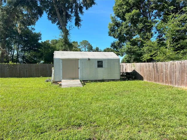 a view of a backyard with a garden and tree