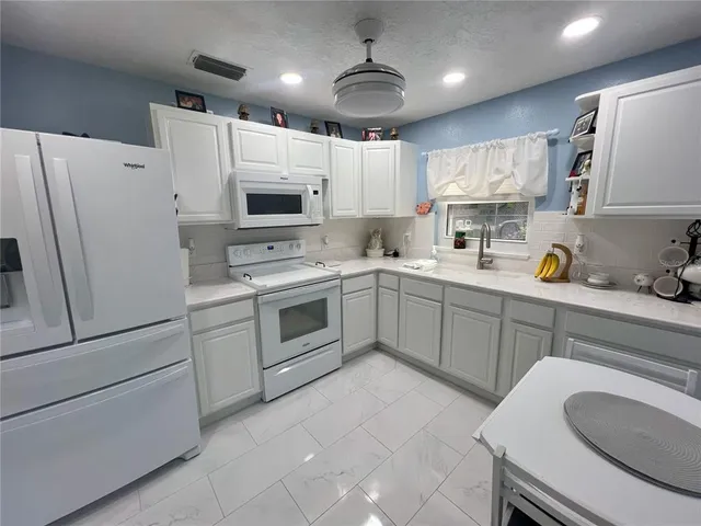 a kitchen with a sink a stove a refrigerator and cabinets