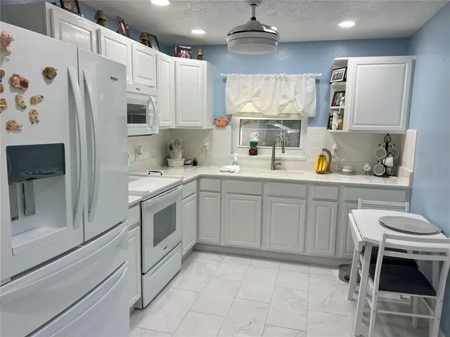 a kitchen with a white cabinets and white appliances