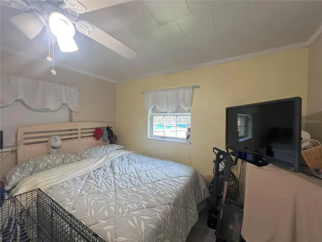 a bedroom with a bed and a tv