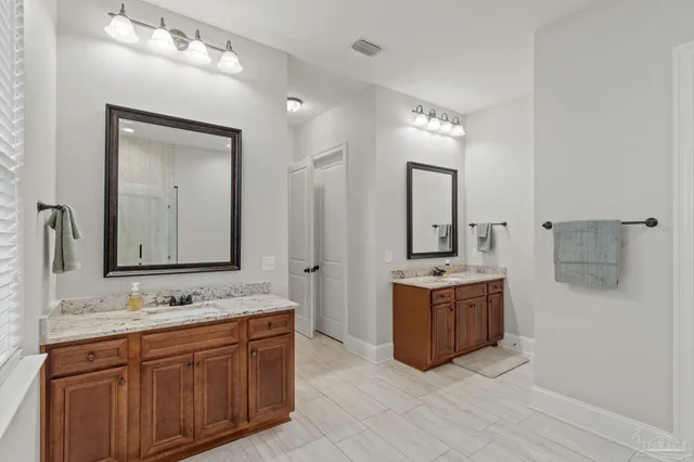 a spacious bathroom with a double vanity sink mirror and bathtub