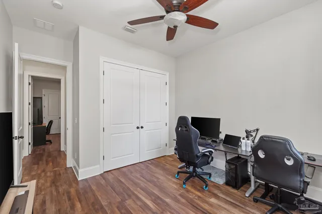 a view of a workspace with wooden floor and a ceiling fan