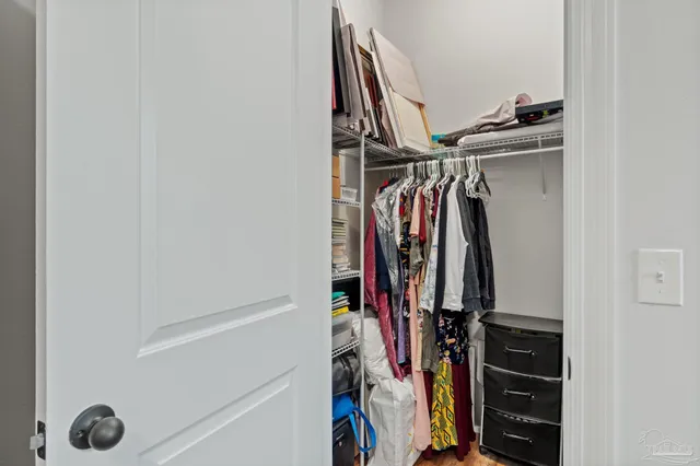 a view of walk in closet with clothes and shoes