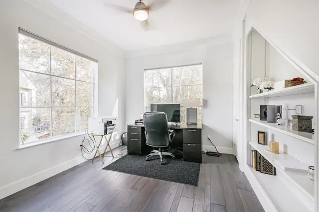 a view of a workspace with furniture and a window
