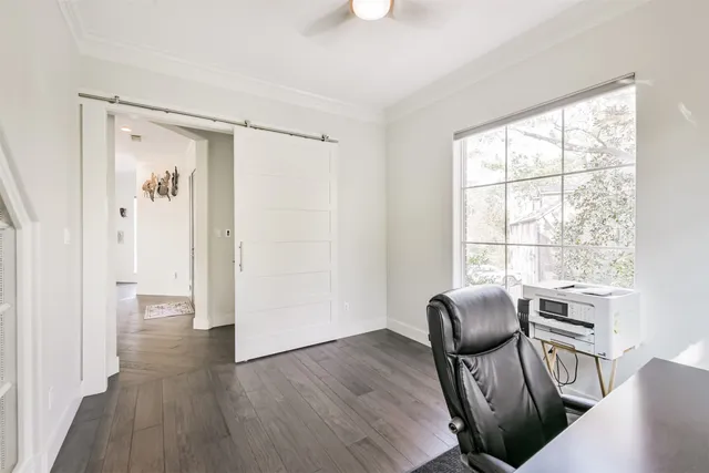 a view of a workspace with furniture and a window