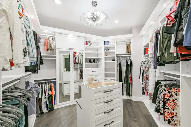 a view of walk in closet with clothes and shoes