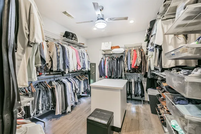 a view of walk in closet with clothes and shoes
