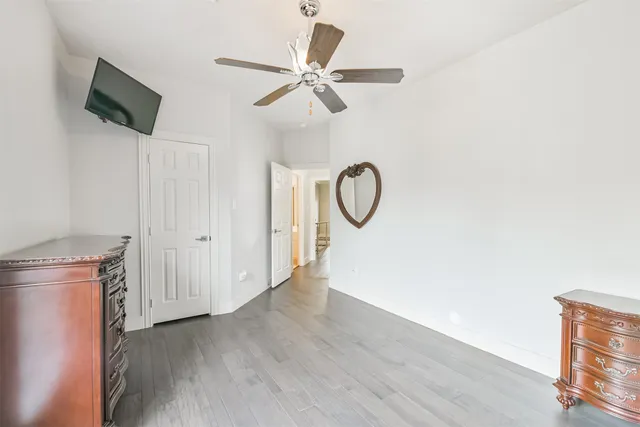 a view of a livingroom with wooden floor and a ceiling fan