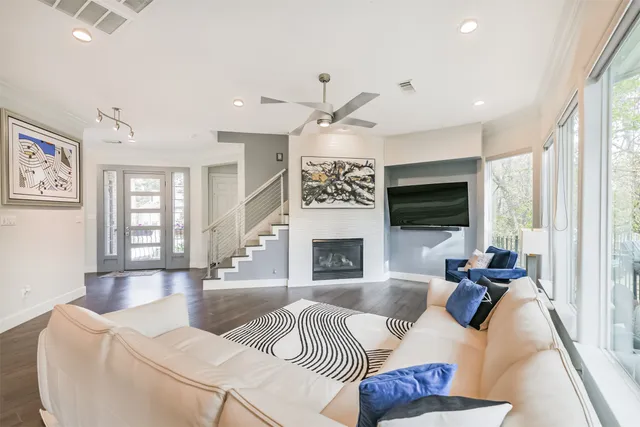 a living room with furniture a fireplace and a large window