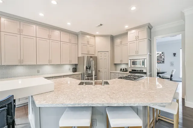 a kitchen with stainless steel appliances granite countertop a sink refrigerator and cabinets