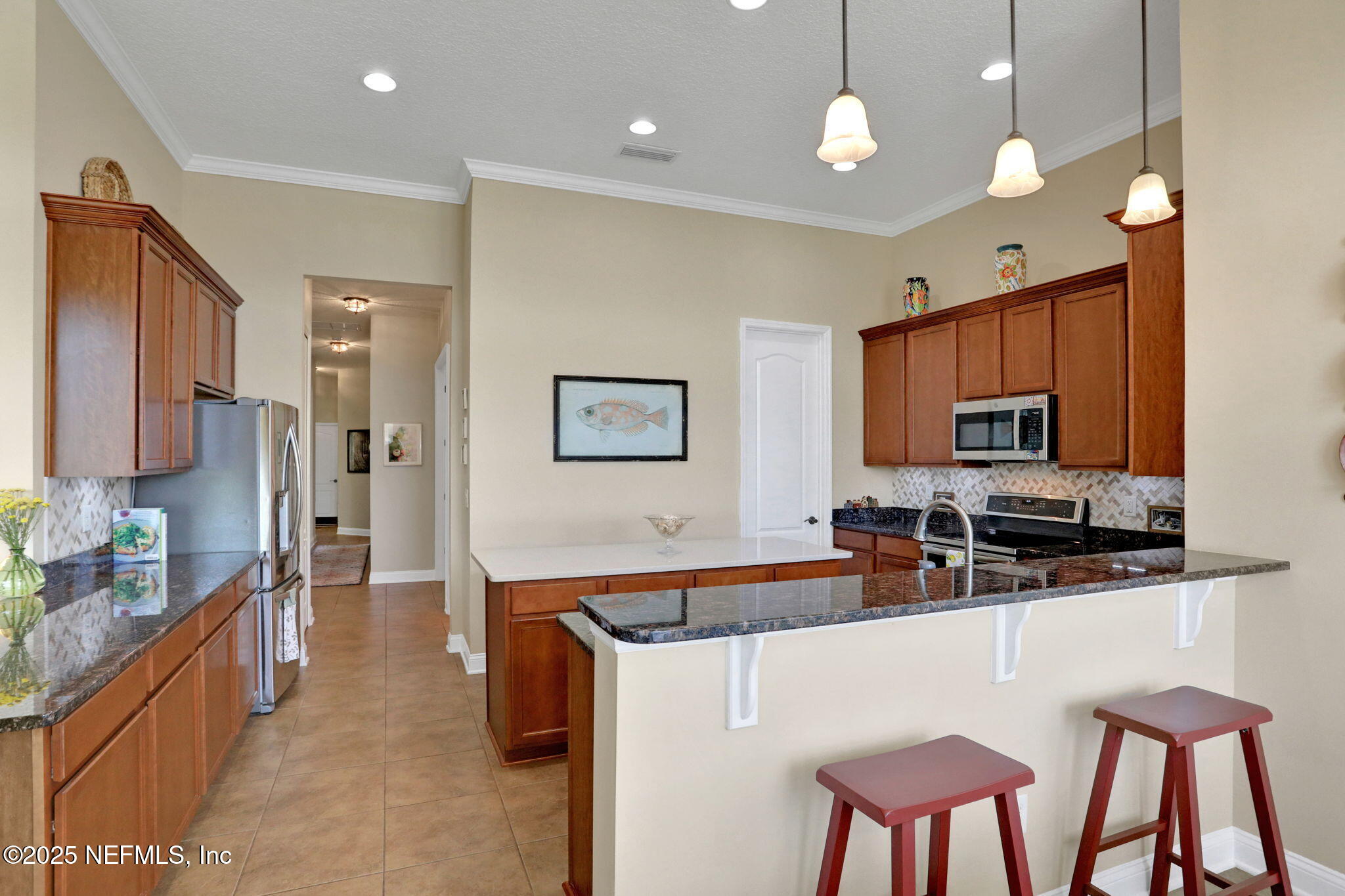 1016 Inverness Drive St. Augustine, FL 32092 - Photo 15 of 59 a large kitchen with kitchen island granite countertop a stove a sink a table and chairs
