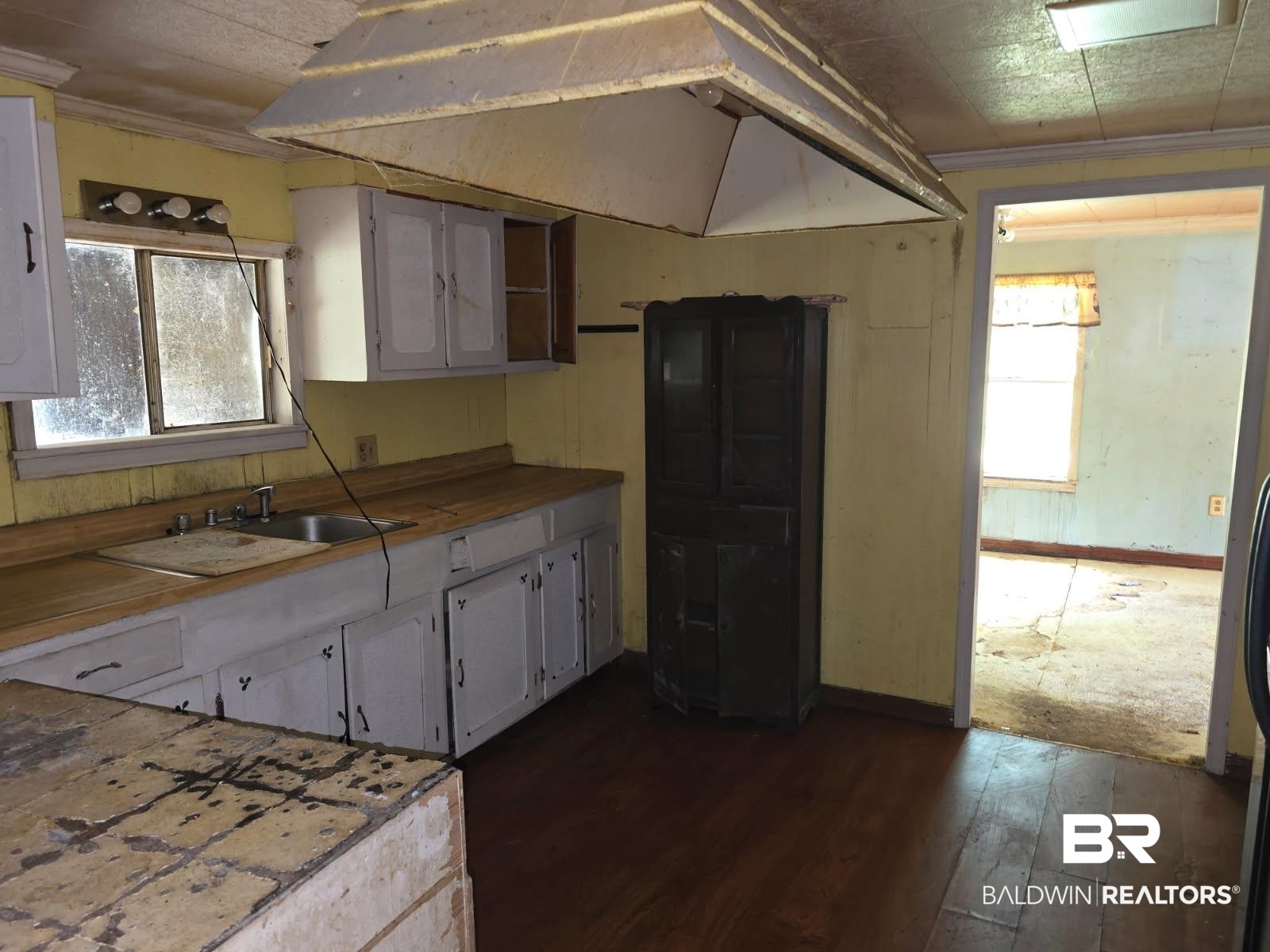 4072 Appleton Road Brewton, AL 36426 - Photo 3 of 7 Kitchen featuring dark wood finished floors, vaulted ceiling, baseboards, a sink, and crown molding