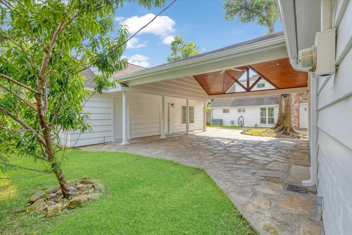 2103 Southwick Street Houston, TX 77080 - Photo 41 of 49 a view of yellow house with a big yard potted plants and large tree