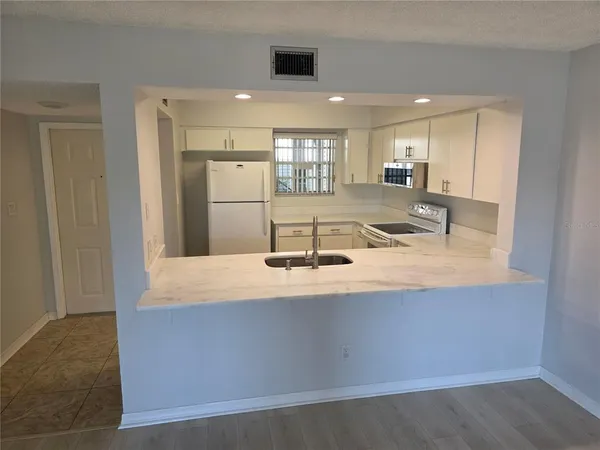 a view of kitchen with kitchen island a sink wooden floor and counter space