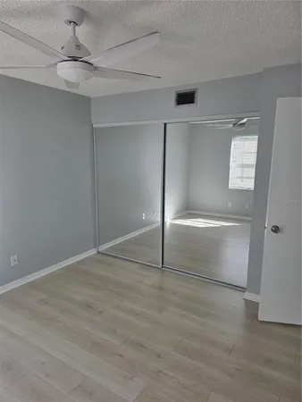 an empty room with windows and fan