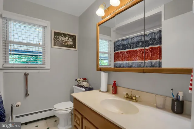 a bathroom with a sink mirror vanity and toilet