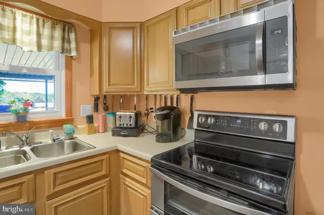 a kitchen with sink a microwave and cabinets