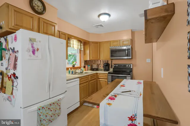 a kitchen with a refrigerator a stove top oven a sink and dishwasher