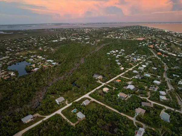 an aerial view of residential house with outdoor space and trees all around