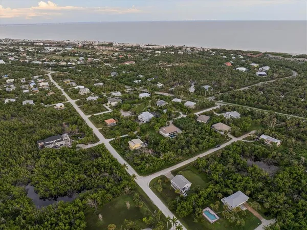 an aerial view of residential houses with outdoor space and trees