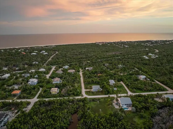 an aerial view of residential houses with outdoor space and trees